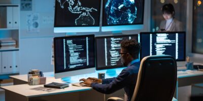 Young contemporary cyber security manager typing in front of computer
